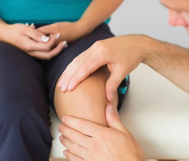 Physiotherapist assessing a patient’s knee
